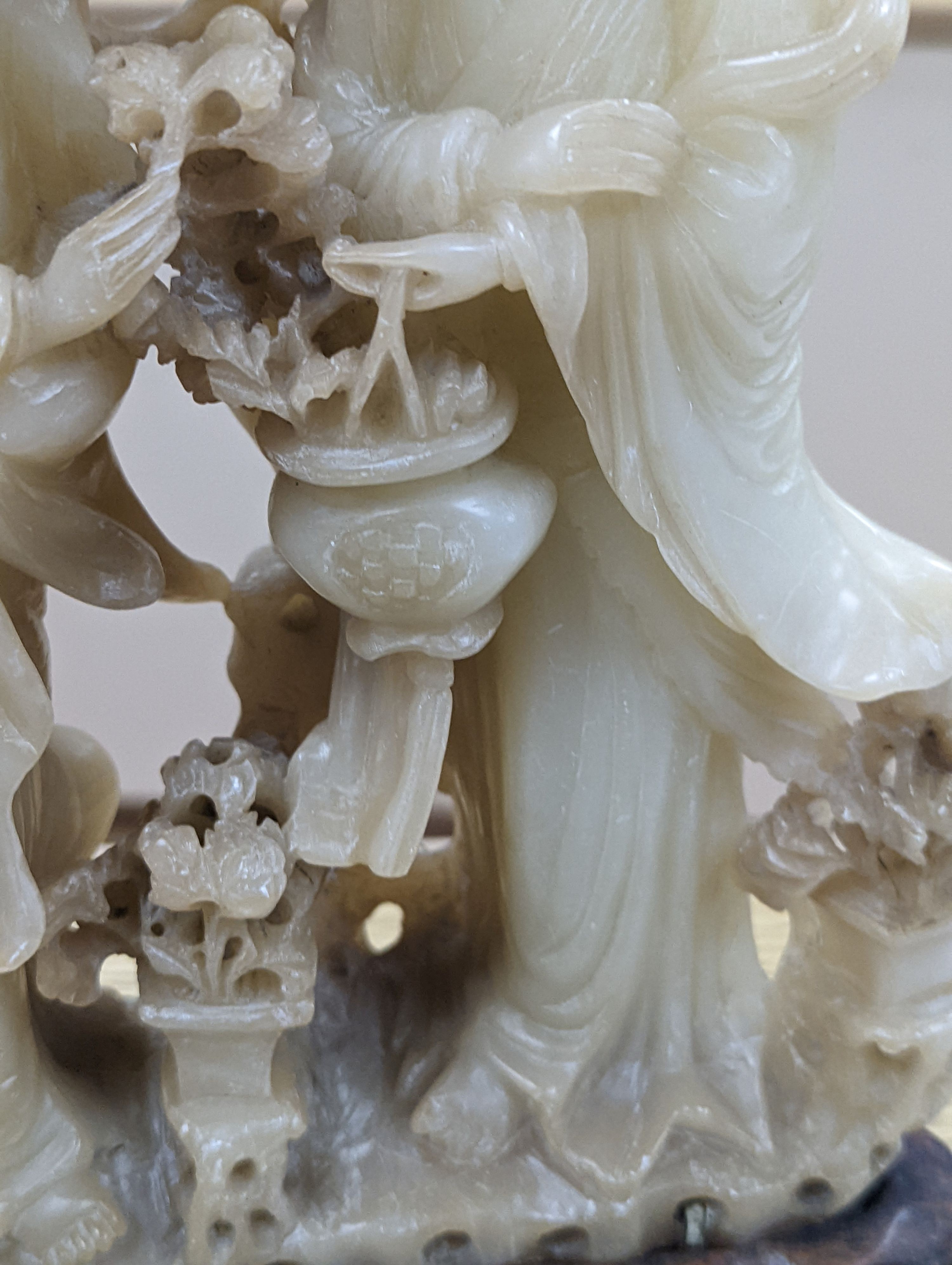 A Chinese soapstone carving of two ladies, wood stand, early 20th century, 36 cms high.
